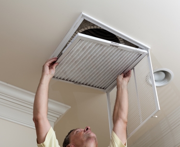 Senior man opening air conditioning filter