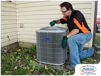 man kneeling to inspect HVAC